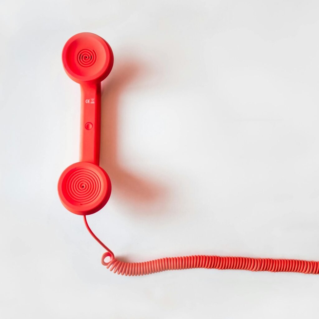 Red Corded Telephone on White Suraface